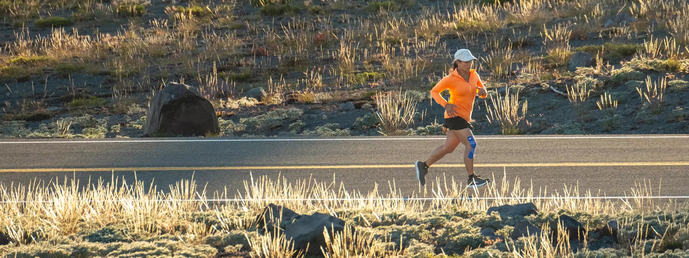 Woman running with KT Tape on knee